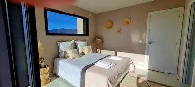 a bedroom with a bed with white sheets and a window at A Vista - Villa luxe, piscine, vue mer panoramique - Classée 4 étoiles in Figari