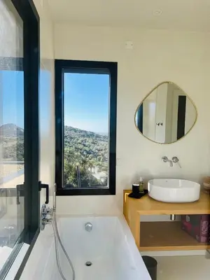 a bathroom with a tub and a sink and a mirror at A Vista - Villa luxe, piscine, vue mer panoramique - Classée 4 étoiles in Figari