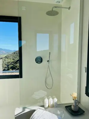 a bathroom with a shower with a glass door at A Vista - Villa luxe, piscine, vue mer panoramique - Classée 4 étoiles in Figari