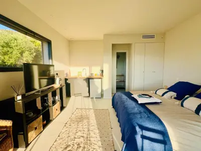 a bedroom with a large bed and a television at A Vista - Villa luxe, piscine, vue mer panoramique - Classée 4 étoiles in Figari