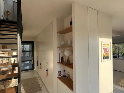a hallway of a house with white walls and wooden shelves at A Vista - Villa luxe, piscine, vue mer panoramique - Classée 4 étoiles in Figari