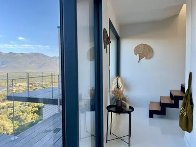 a room with a balcony with a view of the mountains at A Vista - Villa luxe, piscine, vue mer panoramique - Classée 4 étoiles in Figari