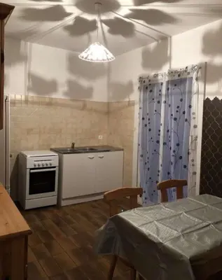 a kitchen with a stove and a table with chairs at Location Estivale en Haute Corse in Scata