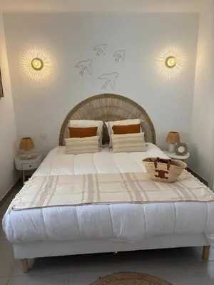 a large white bed in a bedroom with two mirrors at Villa élégante piscine privée Palombaggia Porto-vecchio in Porto-Vecchio