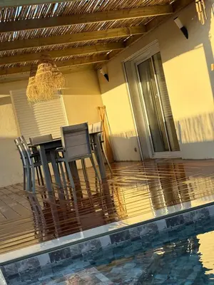a patio with a table and chairs next to a pool at Villa élégante piscine privée Palombaggia Porto-vecchio in Porto-Vecchio
