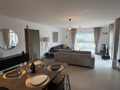 a living room with a couch and a table at Villa élégante piscine privée Palombaggia Porto-vecchio in Porto-Vecchio