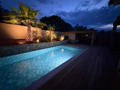 a swimming pool in a backyard at night at Villa élégante piscine privée Palombaggia Porto-vecchio in Porto-Vecchio