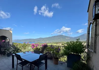 a table and chairs on a balcony with a view at Villa KALLISTE 3 pièces avec vue mer sur les hauteurs de Propriano in Propriano