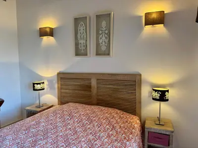 a bedroom with a bed and two lights on the wall at Villa KALLISTE 3 pièces avec vue mer sur les hauteurs de Propriano in Propriano