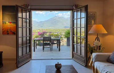 a room with a door open to a patio with a table at Villa KALLISTE 3 pièces avec vue mer sur les hauteurs de Propriano in Propriano