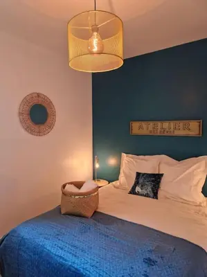 a bedroom with a bed with a blue wall at Mini villa 70 - piscine chauffée in Serra-di-Ferro