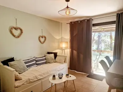 a living room with a couch and a table at Mini villa 70 - piscine chauffée in Serra-di-Ferro