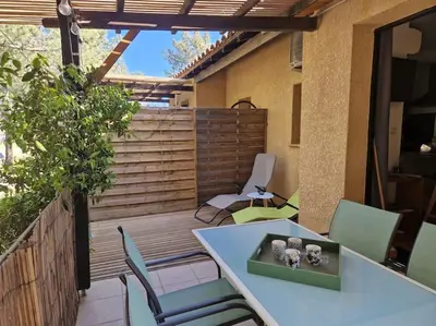 a patio with a table and chairs on a deck at Mini villa 70 - piscine chauffée in Serra-di-Ferro