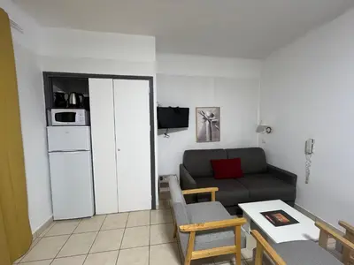 a small living room with a couch and a table at Appartement 2 chambres pour 6 personnes en résidence à la nuitée in Porto Ota
