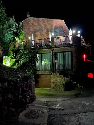 a house with a balcony with a night view at Appartement 2 chambres pour 6 personnes en résidence à la nuitée in Porto Ota