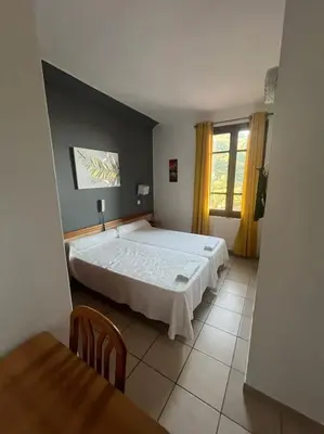 a bedroom with a large bed and a table at Appartement 2 chambres pour 6 personnes en résidence à la nuitée in Porto Ota