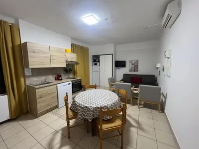a kitchen and dining room with a table and chairs at Appartement 2 chambres pour 6 personnes en résidence à la nuitée in Porto Ota