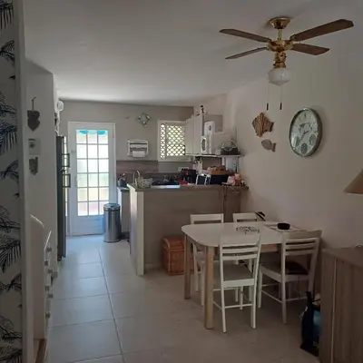 a kitchen and dining room with a table and chairs at A-Tjughina in San Ciprianu