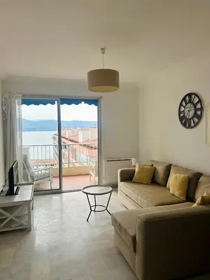 a living room with a couch and a table at T2 vue mer à 8 min du centre ville d'Ajaccio et 1 min des plages in Ajaccio