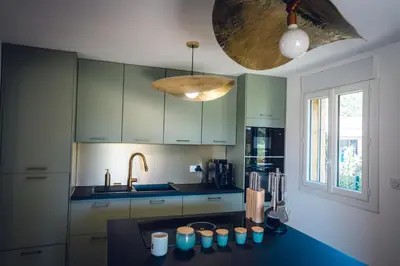 a kitchen with green cabinets and a counter top at Les Villas de Fiori Di Cala Rossa in Lecci