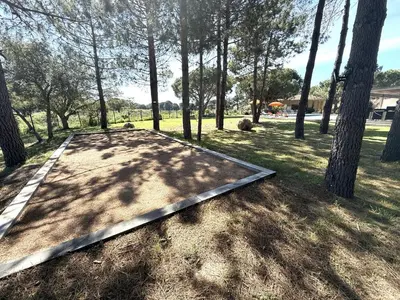 a metal ramp in the middle of a field with trees at Les Villas de Fiori Di Cala Rossa in Lecci