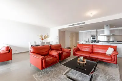a living room with two red couches and a kitchen at Agosta Bella - Appt en face de la plage dAgosta in Albitreccia