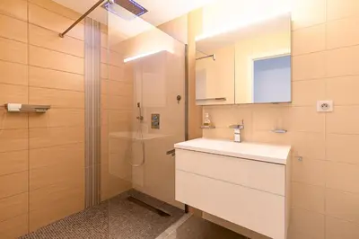 a bathroom with a sink and a shower at Agosta Bella - Appt en face de la plage dAgosta in Albitreccia