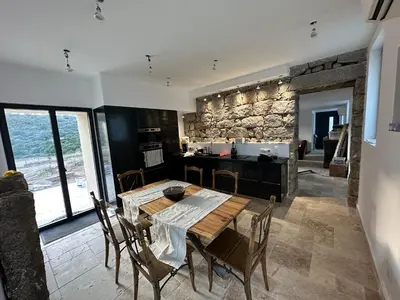 a kitchen and dining room with a wooden table and chairs at Maison cantonnière in Sartène