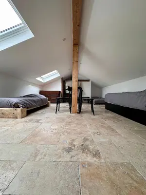 a attic room with two beds and a table at Maison cantonnière in Sartène