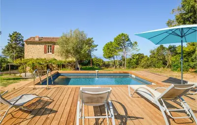 a pool with chairs and an umbrella on a wooden deck at Awesome Home In Coti-Chiavari in Coti-Chiavari