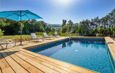 a pool with chairs and an umbrella on a wooden deck at Awesome Home In Coti-Chiavari in Coti-Chiavari