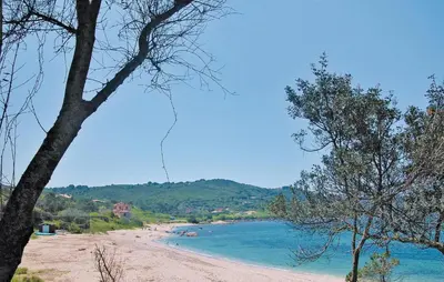 a view of a beach with trees in the foreground at Awesome Home In Coti-Chiavari in Coti-Chiavari