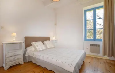 a white bedroom with a bed and a window at Awesome Home In Coti-Chiavari in Coti-Chiavari