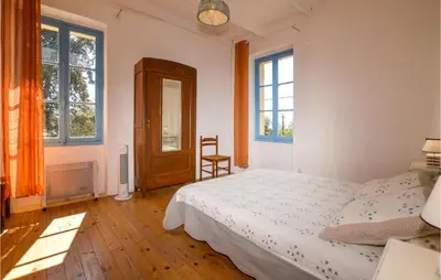a bedroom with a bed and two windows at Awesome Home In Coti-Chiavari in Coti-Chiavari