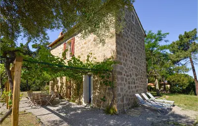 a building with a bunch of chairs next to it at Awesome Home In Coti-Chiavari in Coti-Chiavari