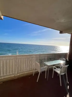 a balcony with a table and chairs and the ocean at Studio vue mer bord de plage in San-Nicolao