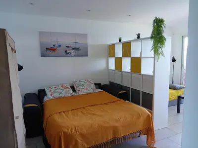 a bedroom with a bed with a orange blanket at Studio vue mer bord de plage in San-Nicolao