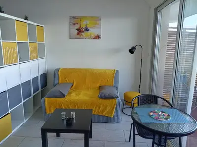 a living room with a yellow couch and a table at Studio vue mer bord de plage in San-Nicolao