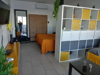 a bedroom with a bed and a white and yellow cabinet at Studio vue mer bord de plage in San-Nicolao