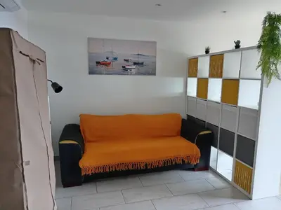 an orange bench in the corner of a room at Studio vue mer bord de plage in San-Nicolao