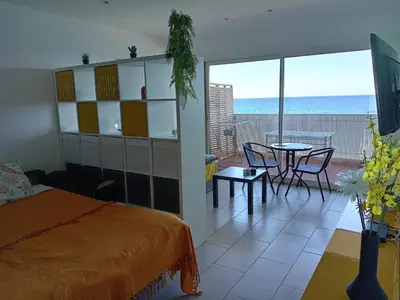 a bedroom with a bed and a view of the ocean at Studio vue mer bord de plage in San-Nicolao