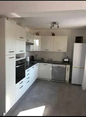 a kitchen with white cabinets and a white refrigerator at Charmante Maisonnette t2bis plaine de Calenzana in Calenzana