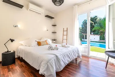 a bedroom with a bed and a large window at Sòle - Peri - Maison climatisée avec piscine in Peri