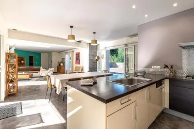a kitchen with a sink and a living room at Sòle - Peri - Maison climatisée avec piscine in Peri