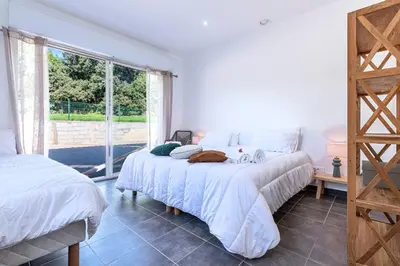 a bedroom with two beds and a large window at Sòle - Peri - Maison climatisée avec piscine in Peri