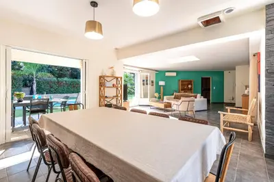 a large living room with a table and chairs at Sòle - Peri - Maison climatisée avec piscine in Peri