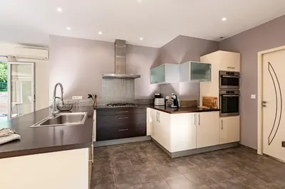 a kitchen with white cabinets and a sink at Sòle - Peri - Maison climatisée avec piscine in Peri