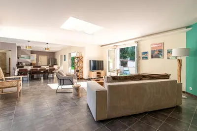 a living room with a couch and a dining room at Sòle - Peri - Maison climatisée avec piscine in Peri