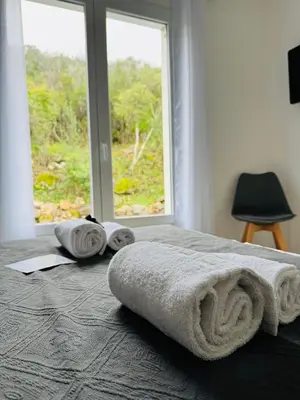 a bed with towels on it with a window at Villa Mare è Machja avec piscine et vue mer in Sari Solenzara