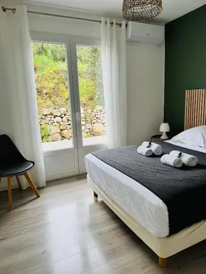 a bedroom with a bed with two towels on it at Villa Mare è Machja avec piscine et vue mer in Sari Solenzara